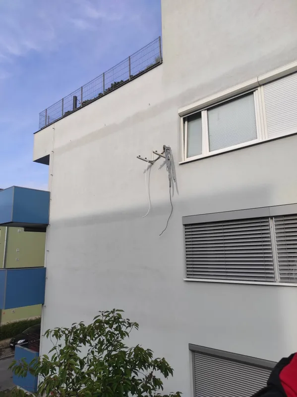 Konzole a rozvody připravené na fasádě panelového domu pro venkovní klimatizační jednotku